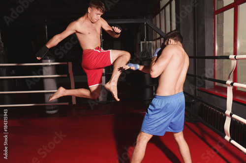 Young professional kickboxers training in ring