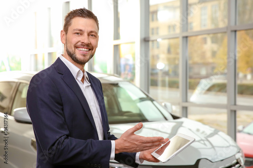 Handsome car salesman with ...