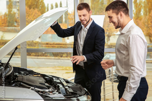 Handsome car salesman with ...