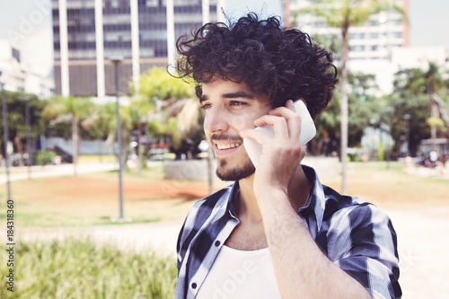 Lachender Hipster Mann am Telefon photo