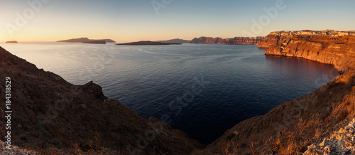 panoramic view of the high rocky cliffs at sunset with surface of the sea and other islands in the background