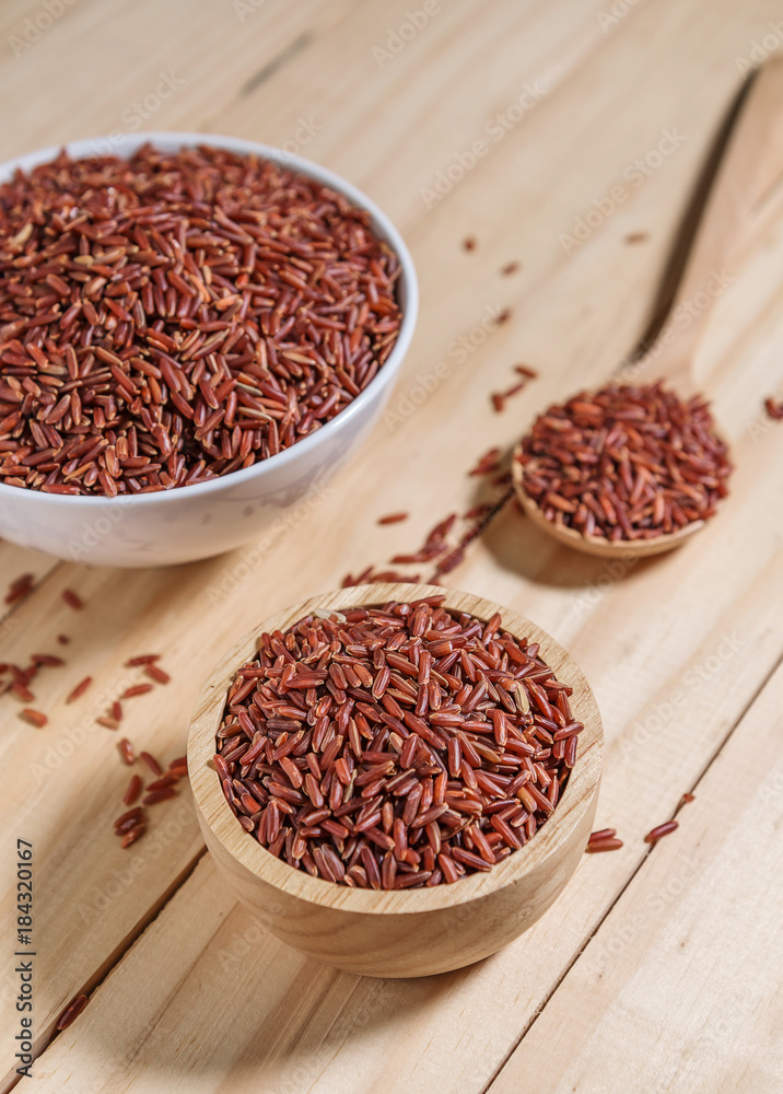 Rice berry in wooden bowl on wood background Rice berry in wooden bowl on wood background