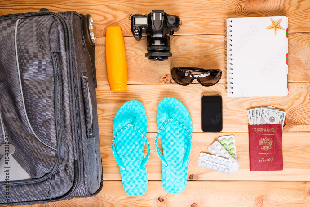 objects travel on a wooden floor near a suitcase objects travel on a wooden floor near a suitcase