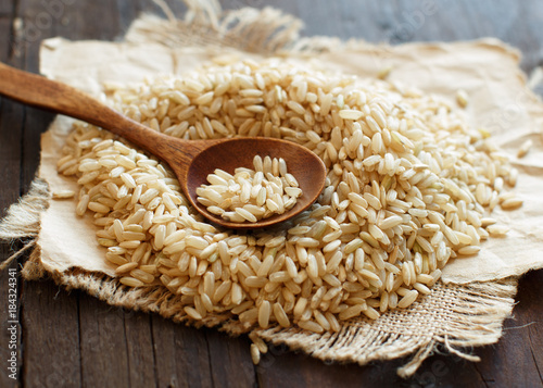 Pile of Brown rice with a wooden spoon photo