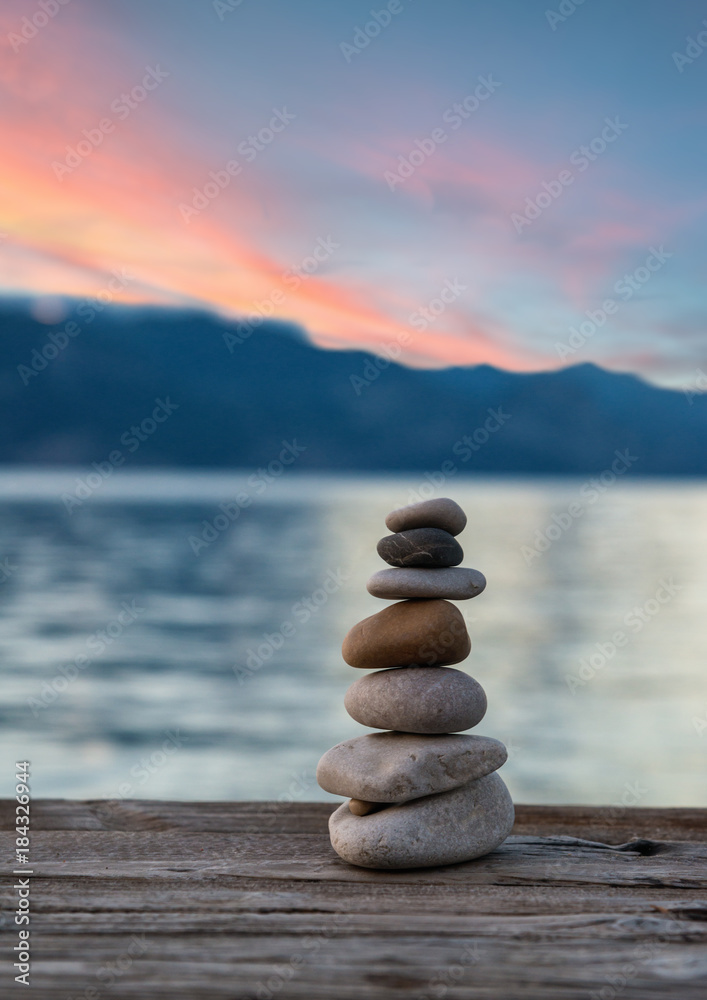 Stones pyramid on wooden pier, relaxation harmony background