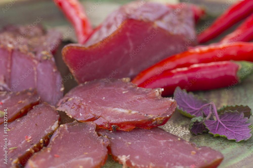 sliced smoked meat and chili among meat, close up. sliced smoked meat and chili among meat, close up.
