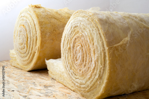 Fotografi roll of mineral wool lying on the wooden floor