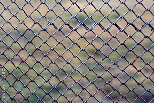 Железная текстура из старой ржавой сетки ограждения в заборе на улице