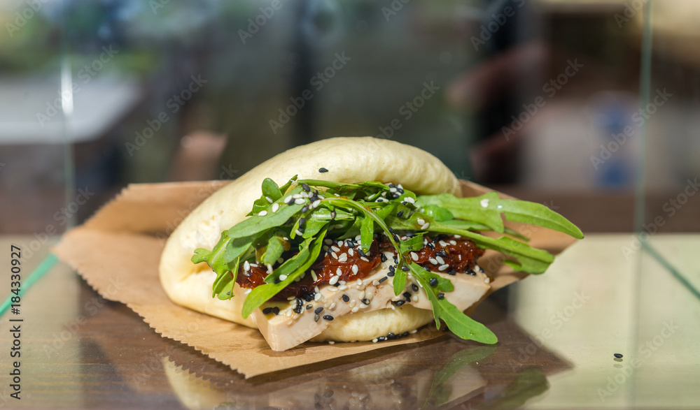 Chinese steamed bun sandwich with tofu, arugula and tomatoes at food festival