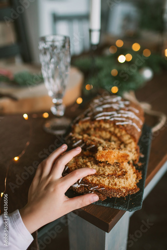 Little girl with cake celebrating Christmas on decorated kitchen