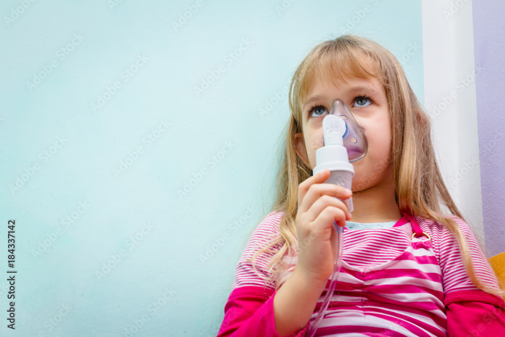 Portrait of sweet little girl using an inhaler