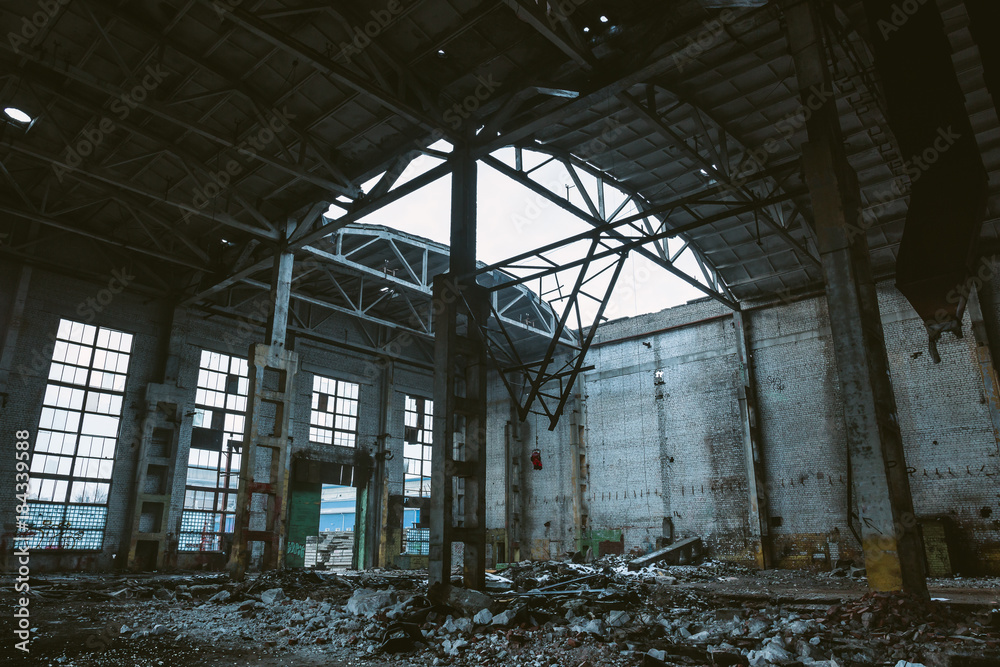 Ruins of large hall of abandoned warehouse or factory, consequences of catastrophe, war, hurricane, earthquake or other natural disaster Ruins of large hall of abandoned warehouse or factory, consequences of catastrophe, war, hurricane, earthquake or other natural disaster