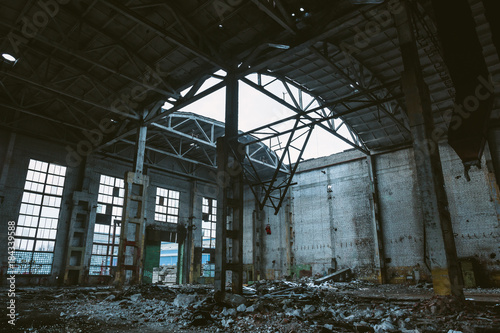 Ruins of large hall of abandoned warehouse or factory, consequences of catastrophe, war, hurricane, earthquake or other natural disaster