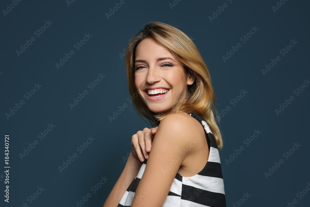 Smiling woman in striped top on color background Smiling woman in striped top on color background