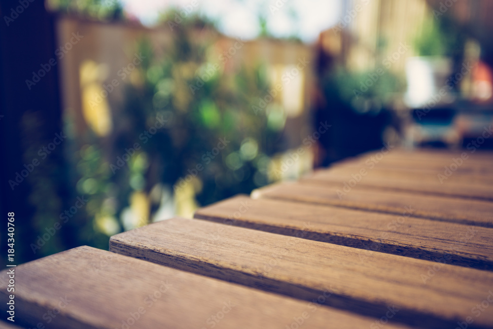 Holztisch im Sommer, verschwommene Pflanzen im Hintergrund, Textfreiraum Holztisch im Sommer, verschwommene Pflanzen im Hintergrund, Textfreiraum