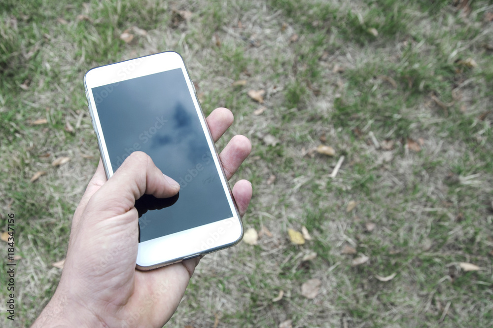 Man hand using a smart phone outdoors. The man sitting and wait for the meeting with a person