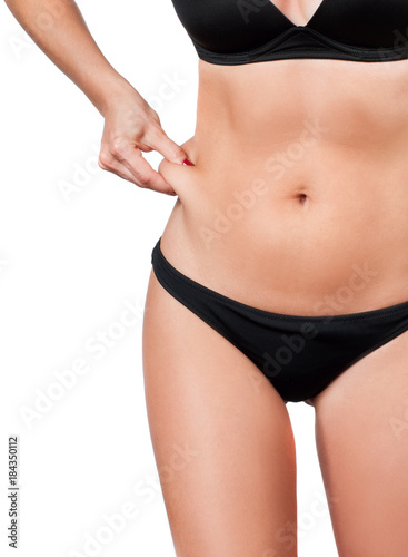 Fat female belly, woman holding her skin for cellulite check.