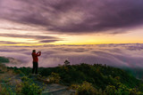 Silhouette of male photographer or traveler taking a photograph sunrise landscape on mountain top at Doi Inthanon National Park, Chiang Mai Province, Thailand