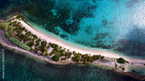 Aerial drone birds eye view of tropical island with white sand and  turquoise clear waters.
