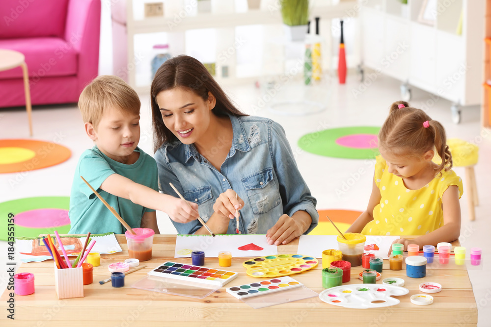 Happy family painting pictures at table indoors Happy family painting pictures at table indoors