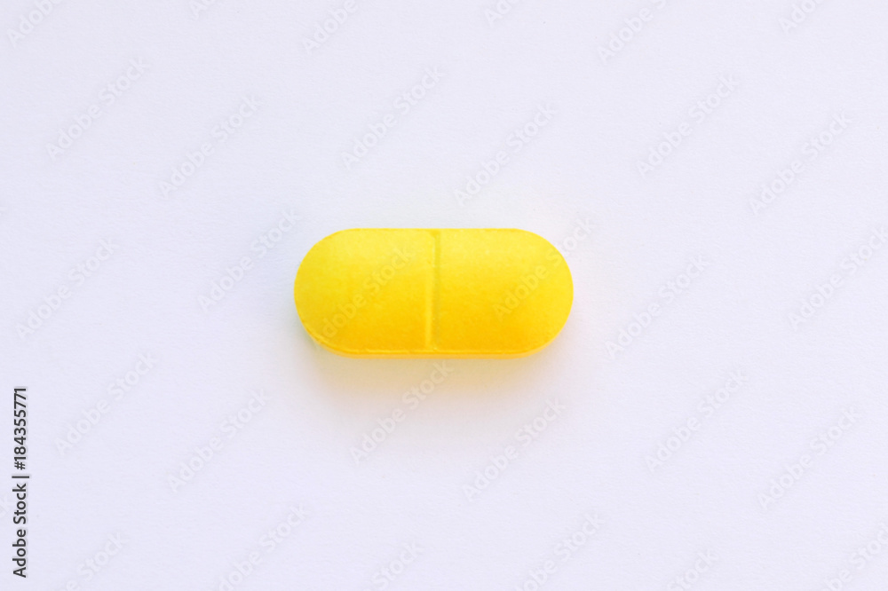 one yellow pill on white isolated background one yellow pill on white isolated background