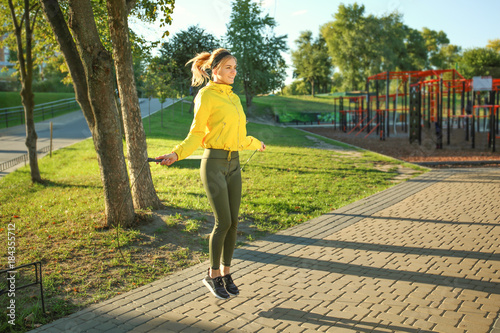 Sporty young woman jumping ...
