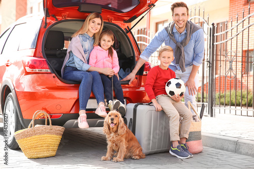 Young family with children and dog near car photo