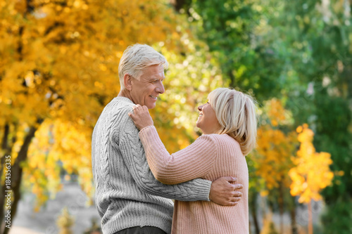 Cute elderly couple dancing in autumn park