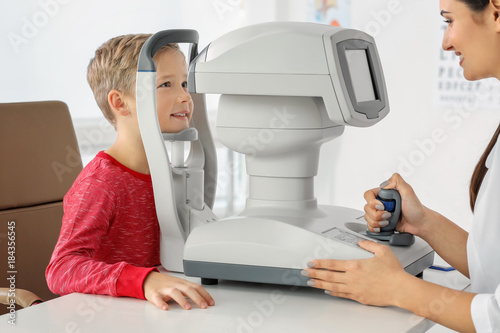 Ophthalmologist measuring intraocular pressure of little child in clinic photo