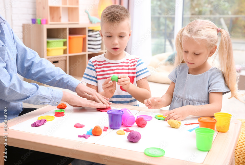 Little children engaged in playdough modeling at daycare Little children engaged in playdough modeling at daycare