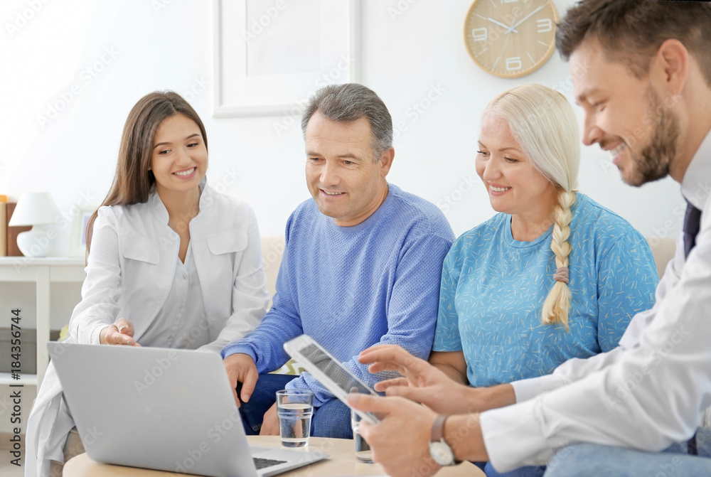 Male insurance agent and doctor with clients in office Male insurance agent and doctor with clients in office