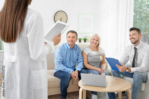 Female doctor with clients at insurance agency