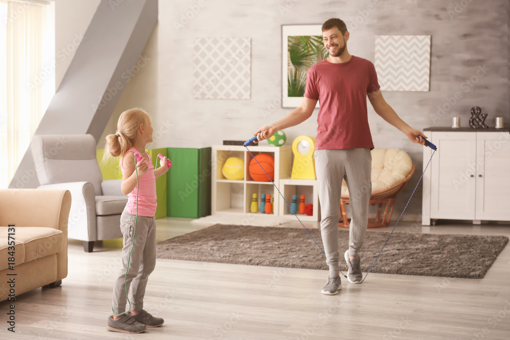 Cute girl and her father jumping rope at home Stock Photo | Adobe Stock