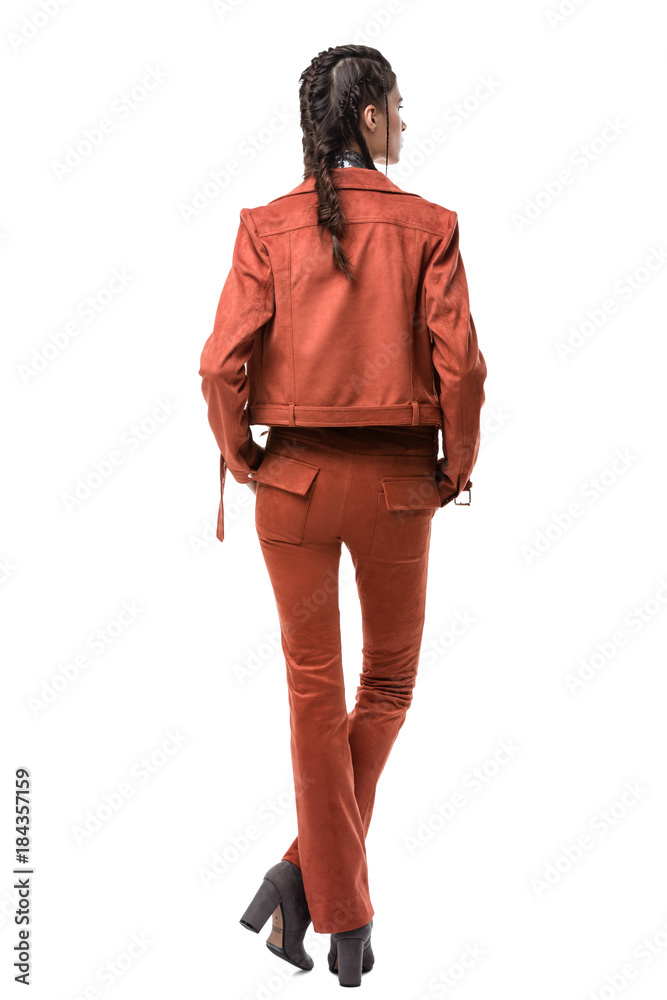 Young pretty lady standing from back in light brown suede jacket and trousers on white background Young pretty lady standing from back in light brown suede jacket and trousers on white background