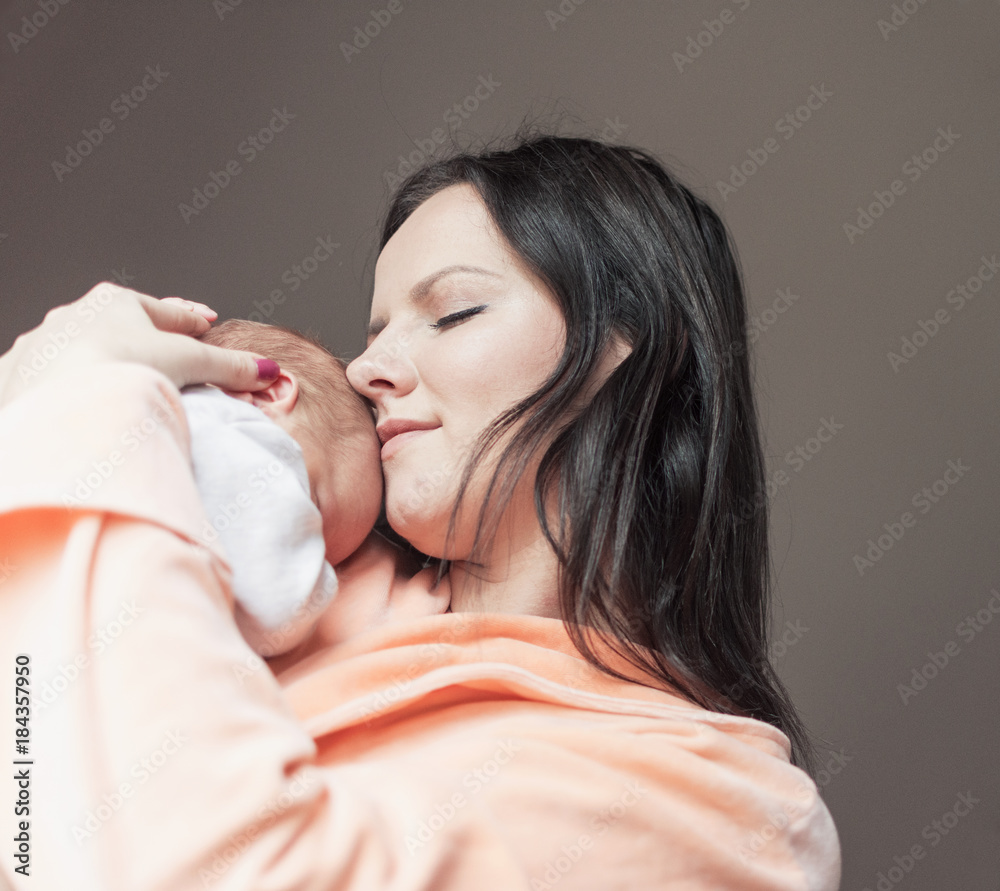 pretty woman holding a newborn baby in her arms pretty woman holding a newborn baby in her arms