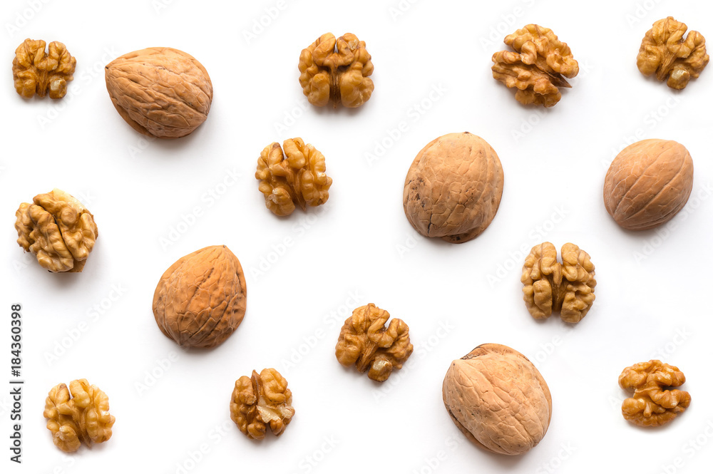Creative Walnut Pattern. Nuts kernel with nutshell on white background. Top view. Creative Walnut Pattern. Nuts kernel with nutshell on white background. Top view.