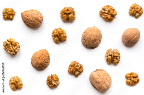 Creative Walnut Pattern. Nuts kernel with nutshell on white background. Top view.
