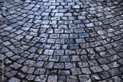 old cobblestone or cobble stone street road surface at night backlit background texture photo