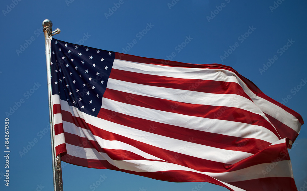 Close up US American flag against blue sky Close up US American flag against blue sky