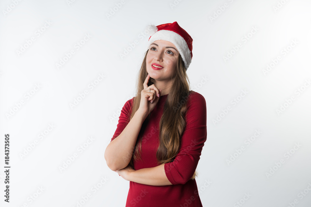 portrait of young christmas woman wearing red santa claus hat dreaming having idea, isolated on white background, copy space portrait of young christmas woman wearing red santa claus hat dreaming having idea, isolated on white background, copy space