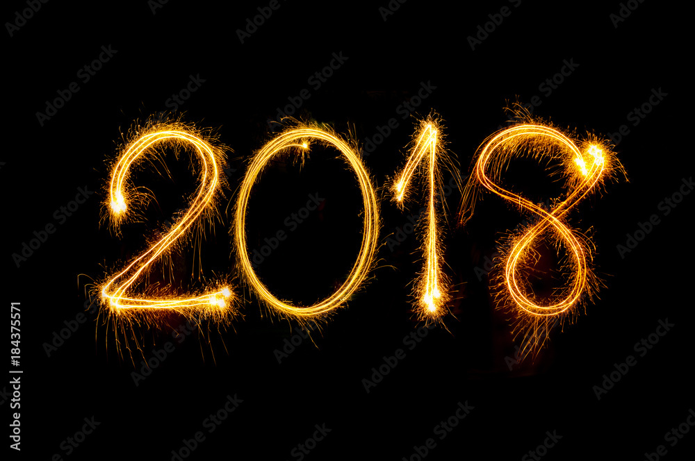 Happy new year 2018 text written with Sparkle fireworks isolated on black background Happy new year 2018 text written with Sparkle fireworks isolated on black background
