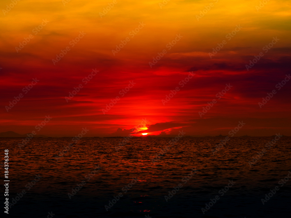 sunset last light of sun on horizontal line over orange sky