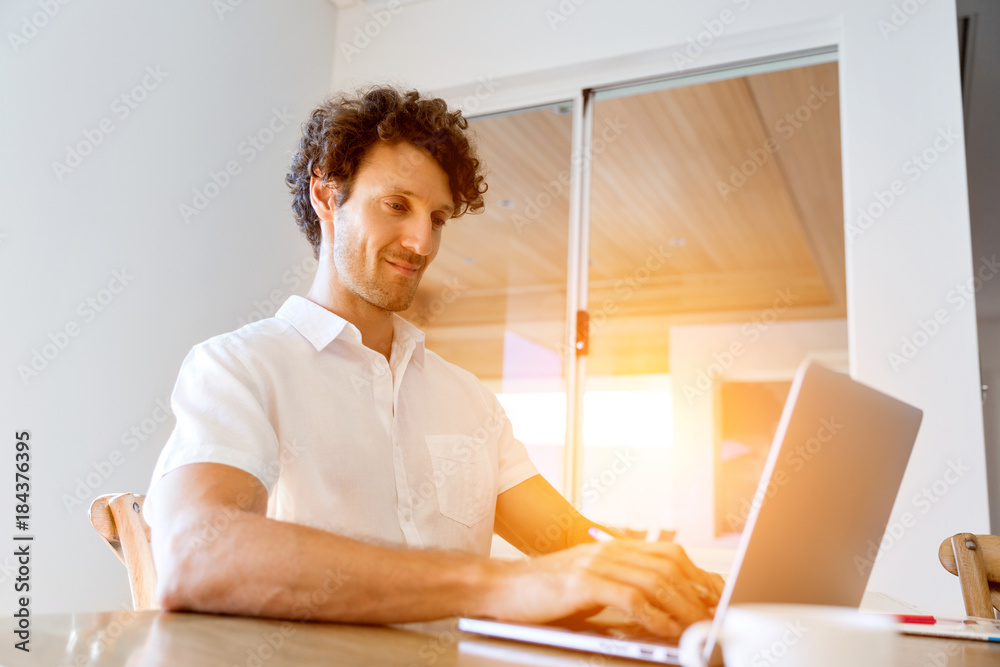 Man working on laptop at home Man working on laptop at home