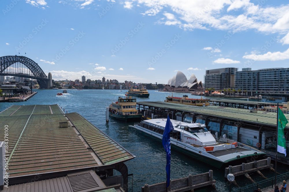 Hafenbecken von Sydney mit der Oper im Hintergrund aus Blickrichtung der Bahnstation