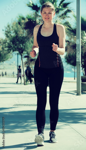 Sporty woman running along embankment © JackF
