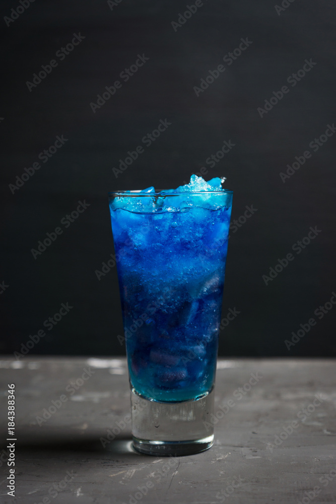 Blue cocktail with cranberry on the wooden background. Selective focus. Blue cocktail with cranberry on the wooden background. Selective focus.