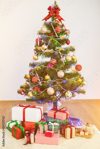 The christmas tree with gift boxes on the floor