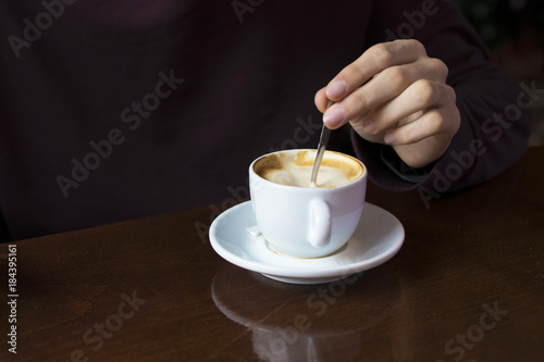 hand with coffee cup in the foreground
