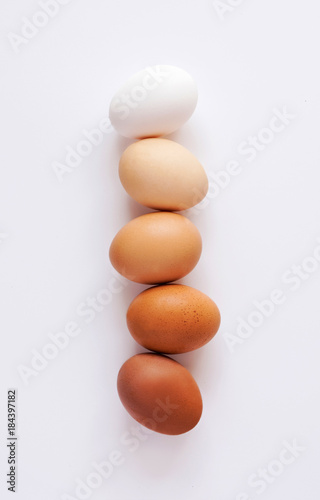 Uova di diverse sfumature in fila su sfondo bianco. Scala di colori