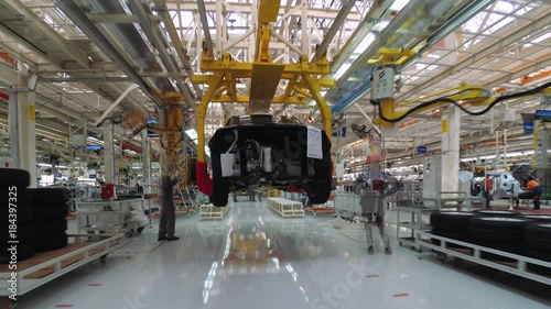 Automobile plant, modern production of cars, car body assembly process, workers serve cars, automated production line. Timelapse.
